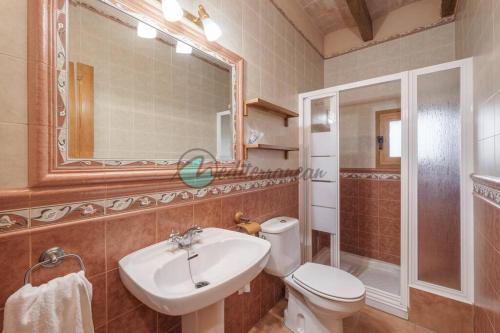 a bathroom with a sink and a toilet and a mirror at Ecovilla ses oliveres by villasmediterranean in Llubí