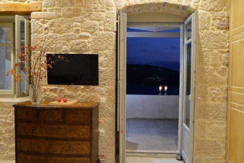 a doorway to a room with a television and a dresser at Akrolithi Boutique Hotel & Suites in Oítilon