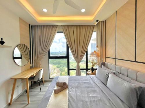 a bedroom with a large bed with a desk and windows at Southkey Mosaic by Antlerzone in Johor Bahru