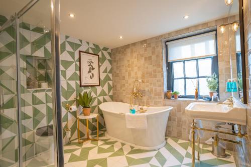 a bathroom with a tub and a sink at Salisbury Arms Hotel in Hertford