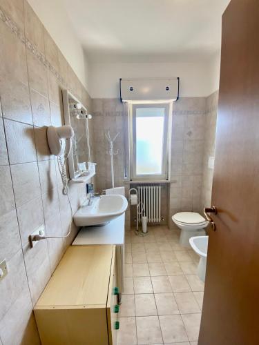 a bathroom with a sink and a toilet at Appartamento Vista Mare con Spiaggia e Piscina in Alba Adriatica