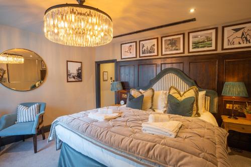 a bedroom with a large bed and a chandelier at Salisbury Arms Hotel in Hertford