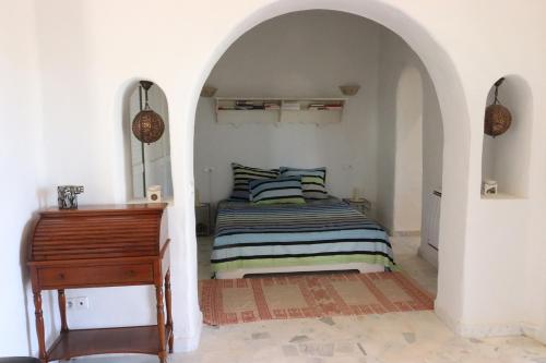 a bedroom with a bed and a piano at Villa Naïa Domaine Béluga Bounouma kerkennah in Sfax