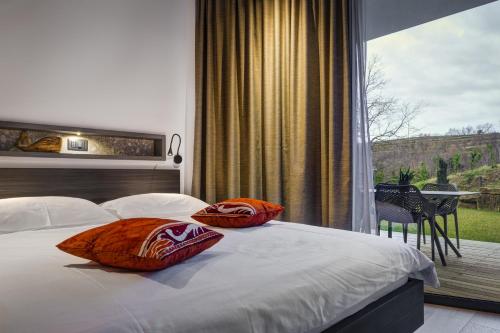 a bedroom with a bed with pillows and a balcony at Larya House in Dobrovo