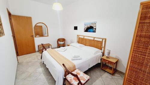 um quarto com uma grande cama branca num quarto em Villette Il Colle em Porto Cesareo