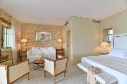 a bedroom with a bed and a living room at Akrolithi Boutique Hotel & Suites in Oítilon