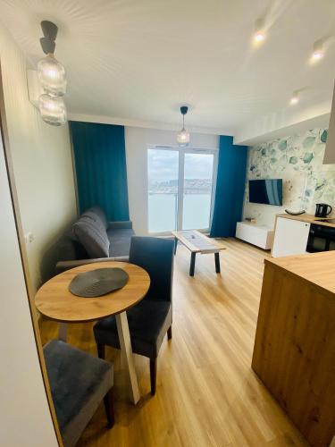 a living room with a table and a couch at Apartamenty Białe nad jeziorem Białym in Augustów
