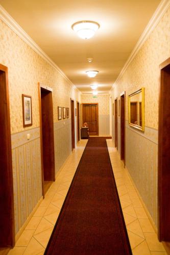 a hallway with a long carpet on the floor at Göcsej Palatinus Étterem és Panzió in Zalaegerszeg