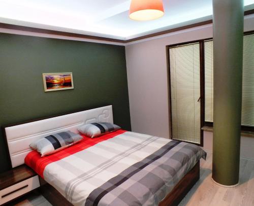 - une chambre avec un lit et un mur vert dans l'établissement Heykel Residence, à Bursa