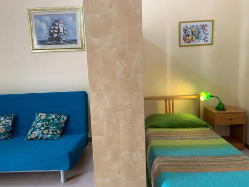Habitación con sofá azul y cama en Appartamento Azzurra en Lecce
