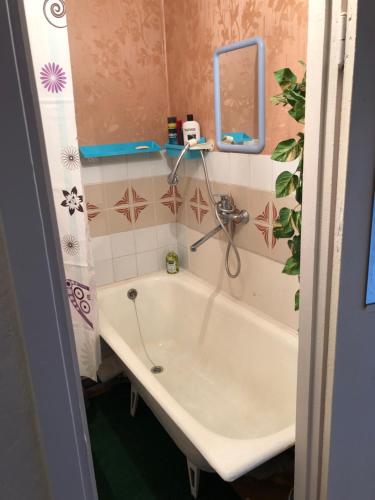 La salle de bains est pourvue d'une baignoire, d'un miroir et d'un lavabo. dans l'établissement Ahtme mnt apartaments, à Ahtme