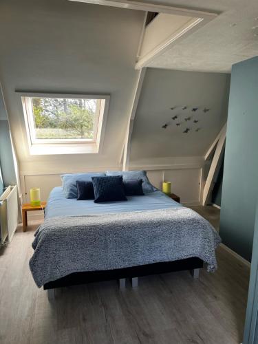 een slaapkamer met een groot bed op zolder bij Veendijkhoeve in Oosterwolde