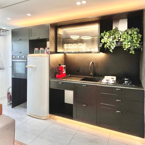 una cucina con armadi neri e frigorifero bianco di Apartamento Vert808 a Lajeado