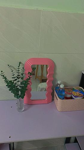a pink number on a table with a vase and a plant at Homestay Tuyết Trinh in Nha Trang
