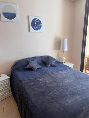 a bedroom with a bed with a blue blanket at Olivia SunSet Blanco in Puerto de Santiago