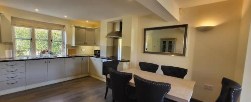 a kitchen with a table and chairs and a mirror at Garden Cottage in Kelling