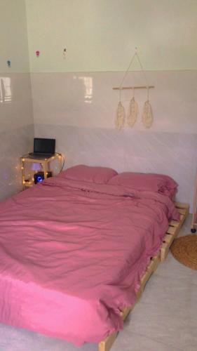 a bedroom with a pink bed with two hangers at Homestay Tuyết Trinh in Nha Trang