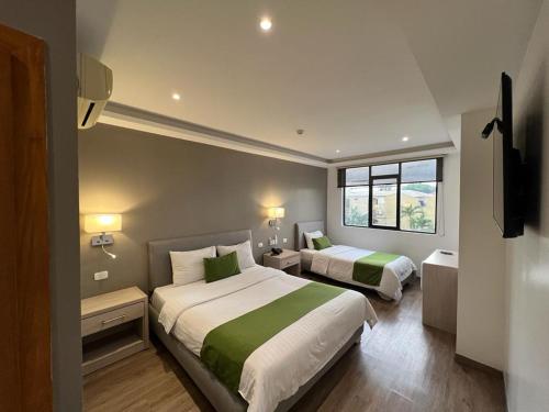 een hotelkamer met 2 bedden en een raam bij Hotel Plaza Monte Carlo in Guayaquil