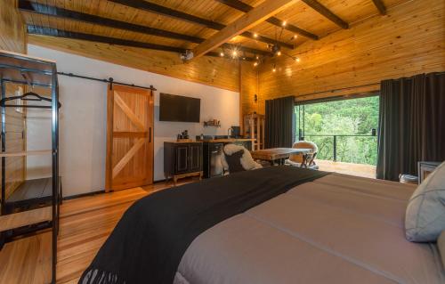 a bedroom with a bed and a sliding glass door at Refúgio Urubici Chalé Boutique in Urubici