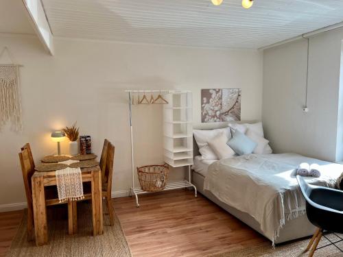 a bedroom with a bed and a table and a desk at Gemütliches Apartment im Viertel mit Flair - Zentral in Bremen