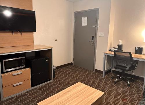 a room with a desk and a computer and a door at Baymont by Wyndham Noblesville in Noblesville