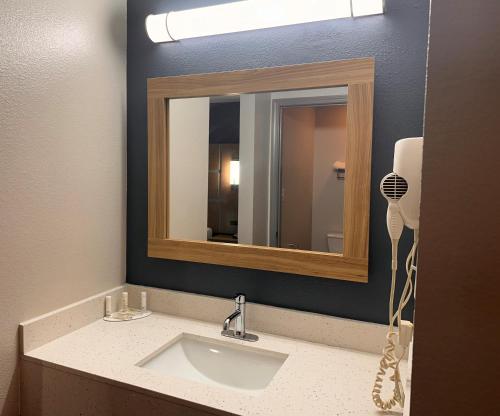 La salle de bains est pourvue d'un lavabo et d'un miroir. dans l'établissement Baymont by Wyndham Noblesville, à Noblesville