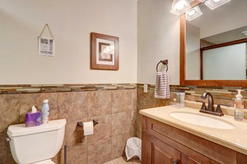 a bathroom with a toilet and a sink and a mirror at Lakefront Vacation Rental with Dock and Views! in Camdenton