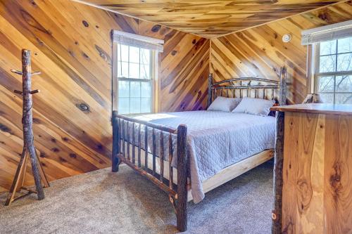 a bedroom with a bed in a log cabin at Racine Vacation Rental 25 Mi to Athens! in Racine