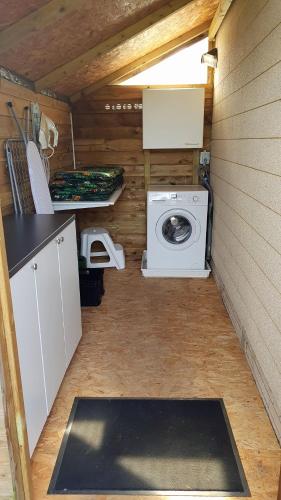 a small kitchen with a washing machine in a cabin at dutchduochalet2 in Heenweg
