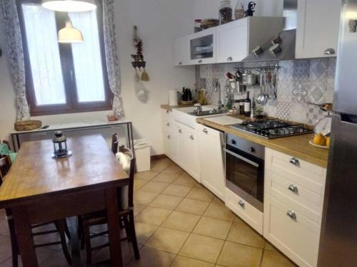 a kitchen with white cabinets and a wooden table at Casale Boschetto Etna in Biancavilla
