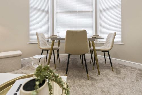 a dining room with a table and four chairs at The Park Road Suites by Central Beach Leisure in Blackpool