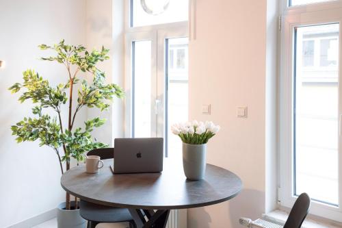a small table with a laptop on it in a room with windows at Origer Apartments by Rentaroo in Luxembourg