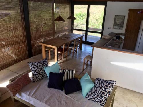 een woonkamer met een bank en een tafel met kussens bij Praia do Silveira Canto Sul in Garopaba