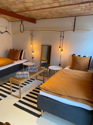 a bedroom with two beds and a table at Porshus Ferielejlighed in Sundstrup