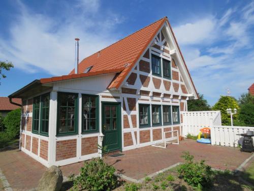 ein Haus mit orangefarbenem Dach und grünen Türen in der Unterkunft Premium-Ferienhaus Elbstar im Feriendorf Altes Land in Bachenbrock