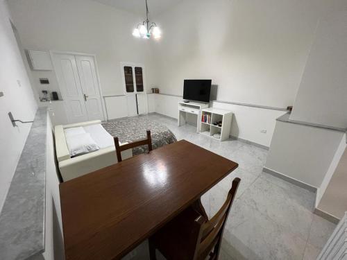 een woonkamer met een houten tafel en een televisie bij Casa Maestrina in Benevento