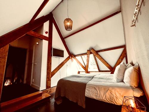 1 dormitorio con 1 cama en una habitación con vigas de madera en Boutique Hotel het Oude Raadhuis, en Castricum