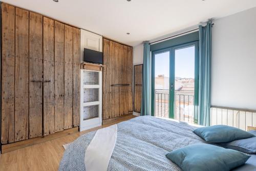 a bedroom with wooden walls and a bed with blue pillows at Cozy apartment in Las Gabias with a great terrace in Las Gabias