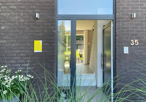 un accès à un bâtiment avec une porte en verre dans l'établissement Arcaden, à Sint-Martens-Voeren