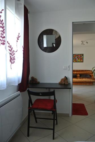 a chair in a room with a mirror on the wall at A L'Orée du Bois in Rillieux