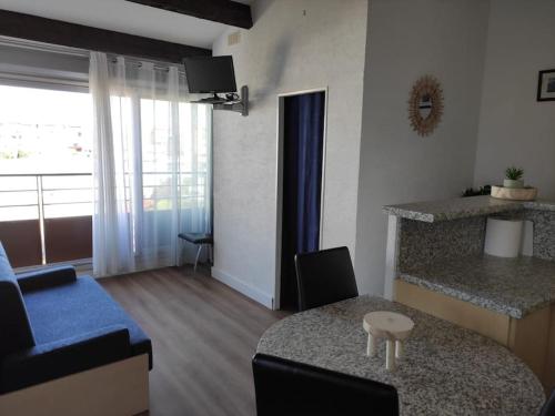 een woonkamer met een blauwe bank en een tafel bij Vacances Ambassades du Soleil in Cap d'Agde