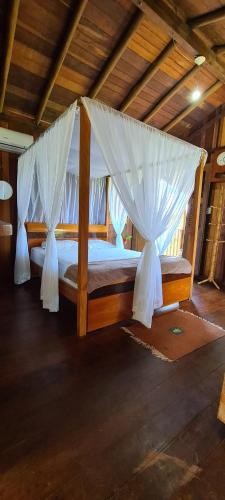una camera con letto a baldacchino e zanzariere di Beach Bangalô Corumbau a Corumbau