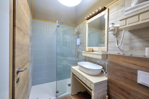 a bathroom with a sink and a glass shower at Lakeside Hotel Plitvice in Plitvička Jezera