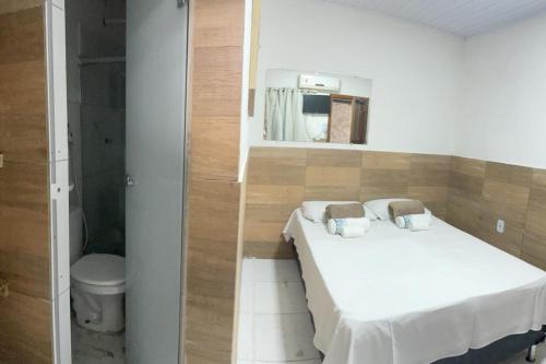 ein kleines Schlafzimmer mit einem Bett und einem Spiegel in der Unterkunft Zaca’s House in Vila Velha