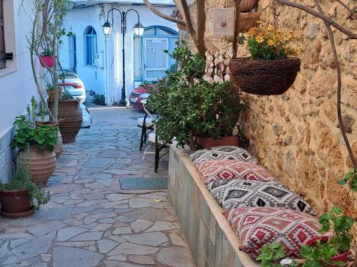 a street with potted plants on a stone wall at Stella Apartments Malia in Malia