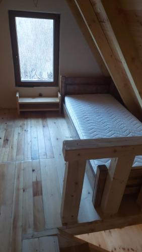 an attic room with a bed and a window at Vila Verusa 2 in Podgorica