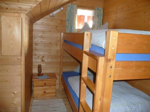 a bedroom with two bunk beds in a log cabin at Haus Edelweiß in Unterwössen
