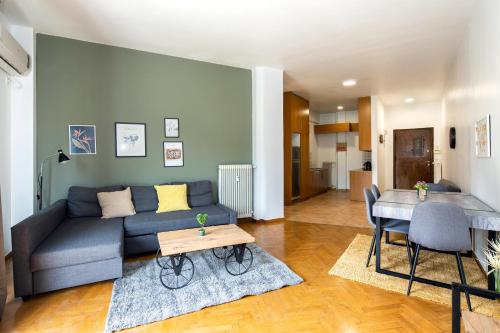 ein Wohnzimmer mit einem Sofa und einem Tisch in der Unterkunft Panoramic view apartment next to Acropolis in Athen