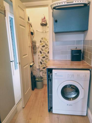 a washer and dryer in a laundry room with a wall at Beeswing, a Victorian Gem in Biggar in Biggar