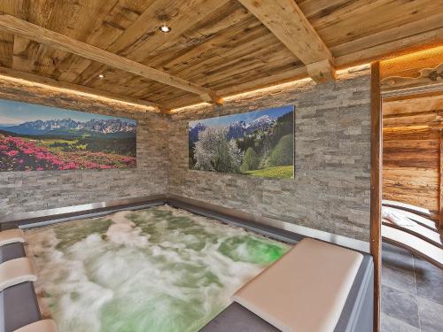 a hot tub in a room with a stone wall at Chalet Piz da Peres in Valdaora
